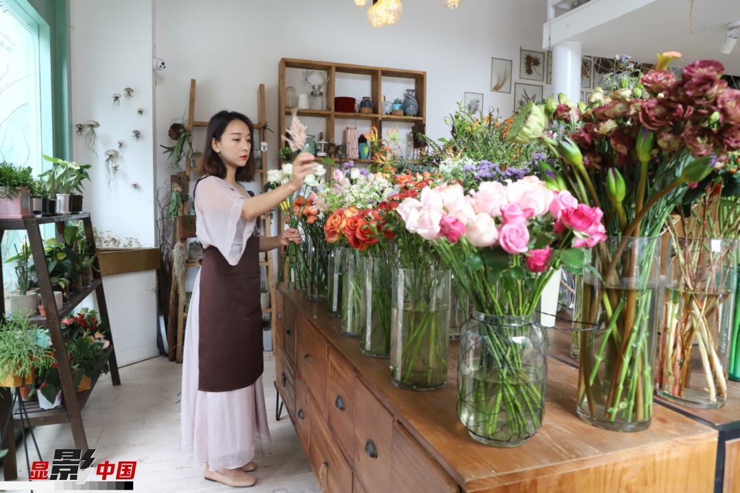 王黎媛是一名河南姑娘，在昆明念完大學(xué)后，就再也舍不下春城的藍(lán)天陽(yáng)光、青山碧水，更舍不下這里的四時(shí)繁花，于是就干脆留了下來(lái)，成了一名媒體人。2017年的時(shí)候又毅然辭去工作，創(chuàng)業(yè)開(kāi)起了花店，成了都市里的一名“花房姑娘”。圖為王黎媛在自己的花店中整理鮮花。新華網(wǎng) 周亞平/攝 念新洪/文