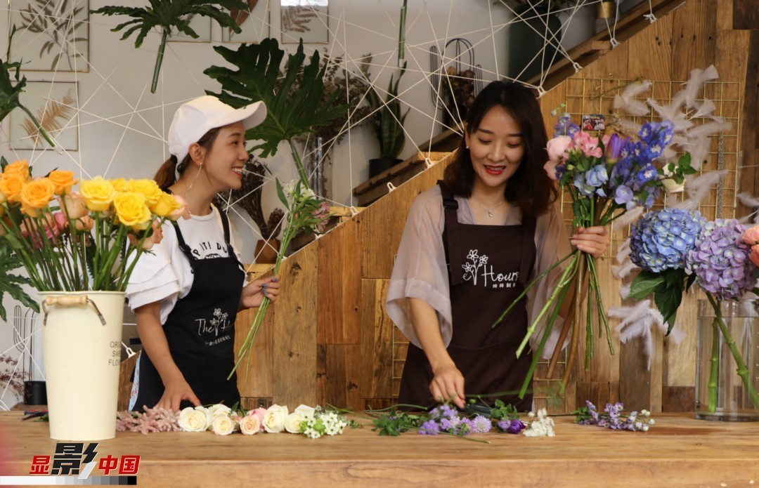 “昆明是鮮花的原產(chǎn)地，有亞洲最大的鮮切花交易市場(chǎng)，可以說(shuō)具備開花店的天時(shí)地利；另外和很多女孩一樣，我從小也就有開花店的夢(mèng)想！”說(shuō)起當(dāng)初的決定，王黎媛說(shuō)一是因?yàn)閴?mèng)想，另外也跟昆明這個(gè)城市產(chǎn)花、賣花的“基因”有關(guān)。圖為王黎媛和同事在制作花束。新華網(wǎng) 周亞平/攝 念新洪/文